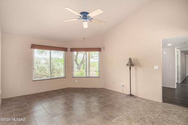 tiled empty room featuring vaulted ceiling and ceiling fan