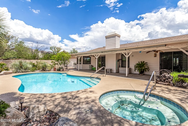 view of swimming pool with ceiling fan, an in ground hot tub, and a patio