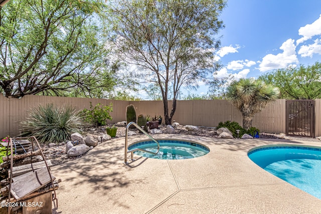 view of pool with a jacuzzi and a patio area