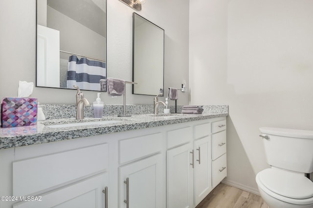 bathroom with a shower with shower curtain, hardwood / wood-style floors, vanity, and toilet