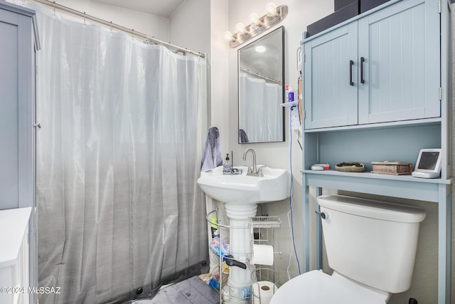 bathroom featuring toilet and curtained shower