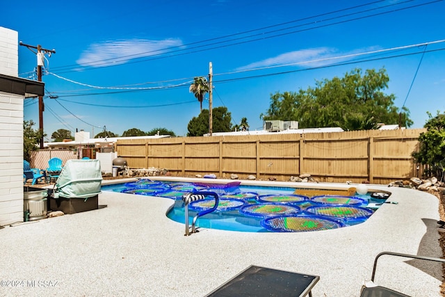 view of pool featuring a jacuzzi and a patio