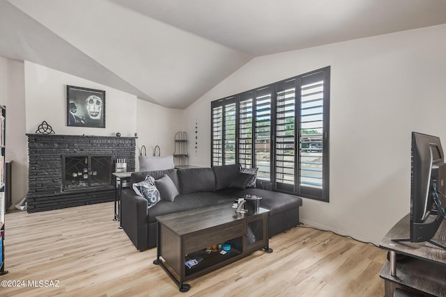 living room featuring a fireplace, vaulted ceiling, and light hardwood / wood-style flooring