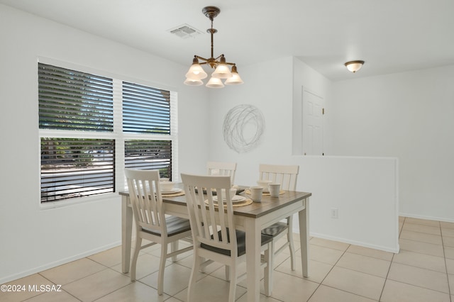 dining area with an inviting chandelier and light tile patterned flooring