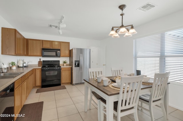 kitchen with sink, hanging light fixtures, light tile patterned floors, black appliances, and an inviting chandelier