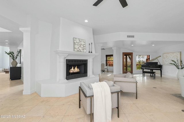 tiled living room featuring ornate columns and ceiling fan