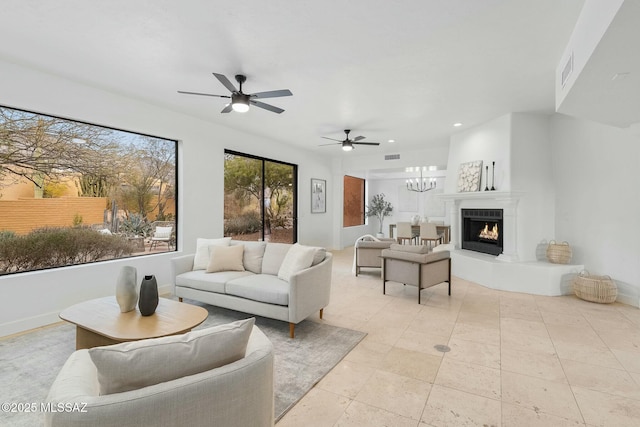 living room featuring ceiling fan with notable chandelier