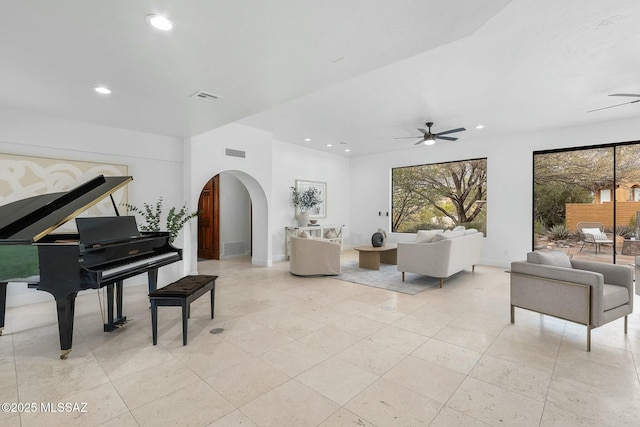 living room featuring a wealth of natural light and ceiling fan