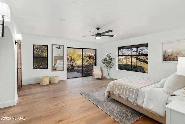 bedroom with ceiling fan, light hardwood / wood-style floors, multiple windows, and access to outside