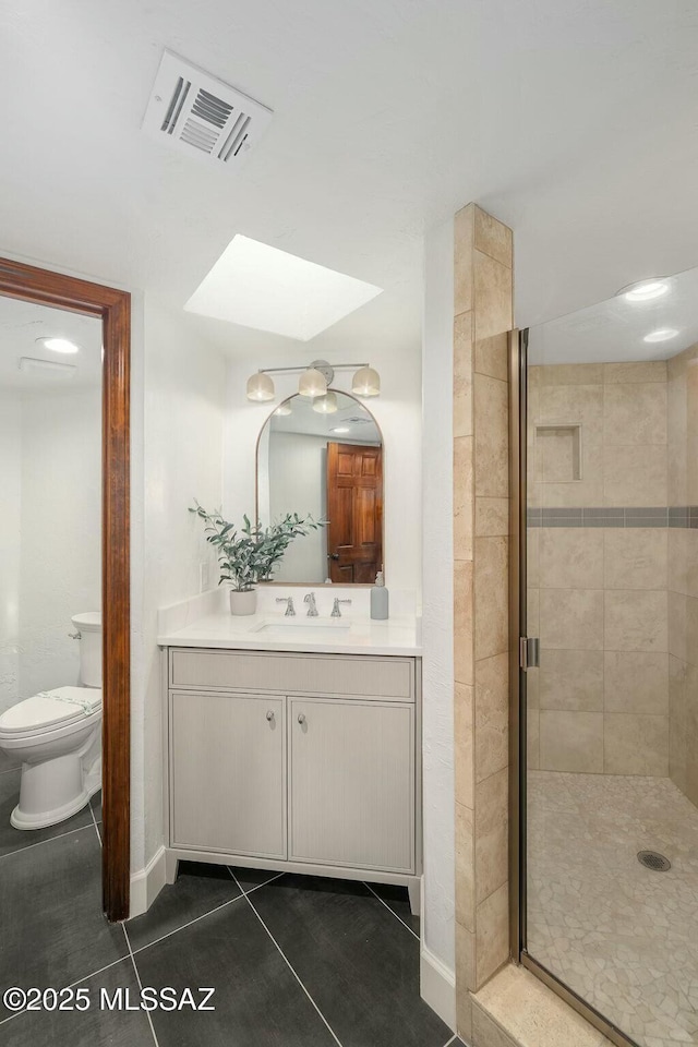 bathroom featuring vanity, toilet, an enclosed shower, and tile patterned flooring