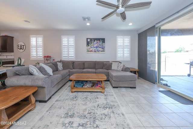 living room with light tile patterned floors, a wealth of natural light, and ceiling fan