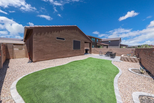 rear view of house featuring a patio area and a yard