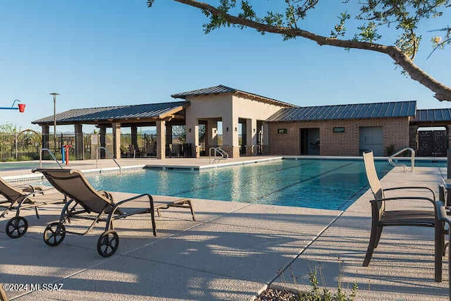 view of pool featuring a patio area, an outbuilding, and a water slide