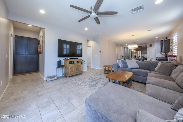 living room with light tile patterned floors and ceiling fan with notable chandelier