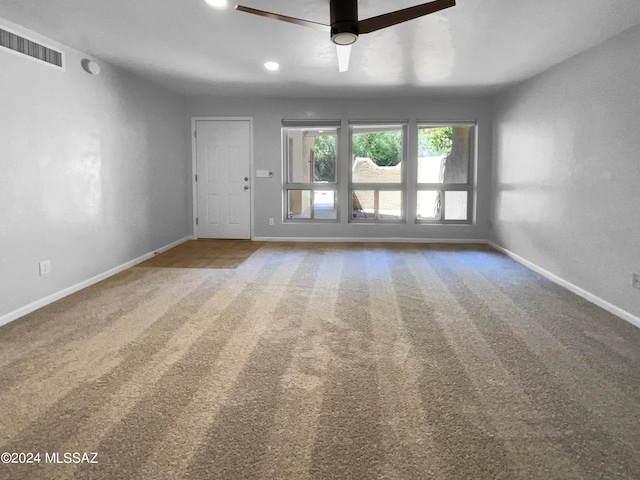 unfurnished living room featuring carpet flooring and ceiling fan