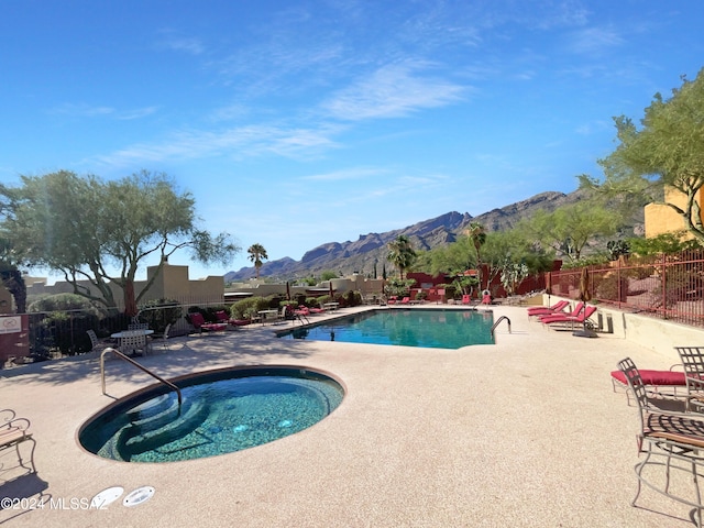 view of swimming pool featuring a mountain view, a patio, and a hot tub