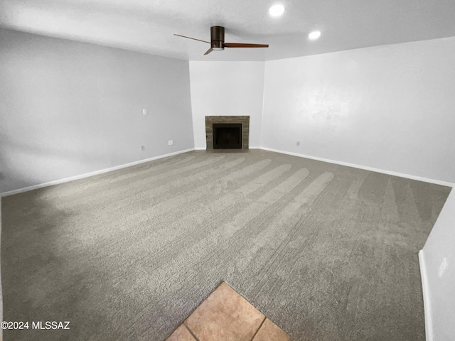 unfurnished living room featuring carpet, ceiling fan, and a fireplace