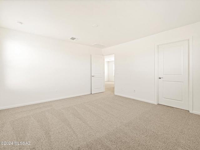 spare room featuring light carpet