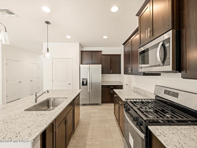 kitchen with sink, stainless steel appliances, light stone countertops, and hanging light fixtures