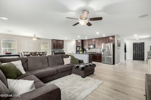 living room with ceiling fan and light hardwood / wood-style floors