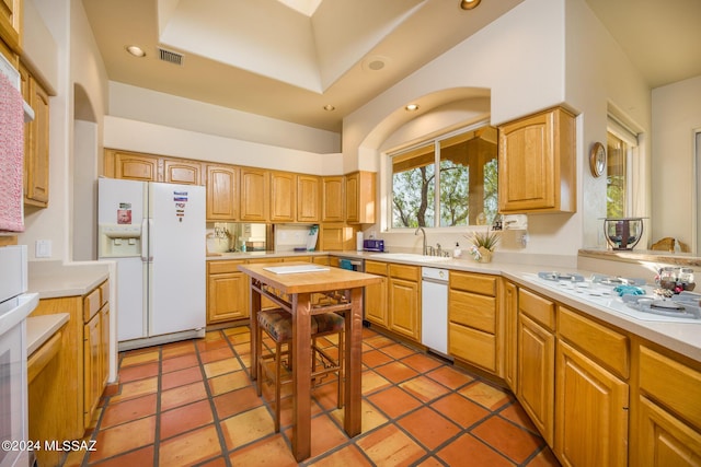 kitchen with white appliances, tile patterned flooring, and sink