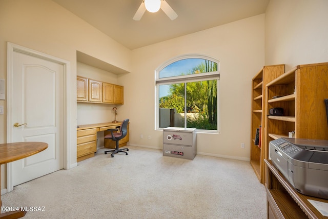 carpeted home office featuring built in desk and ceiling fan