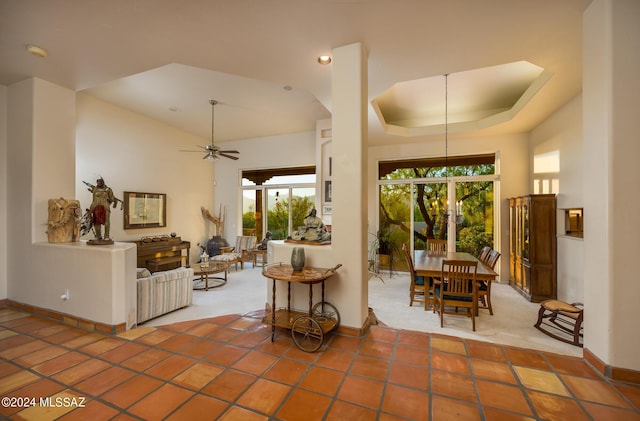 interior space featuring a towering ceiling, ceiling fan, and a tray ceiling