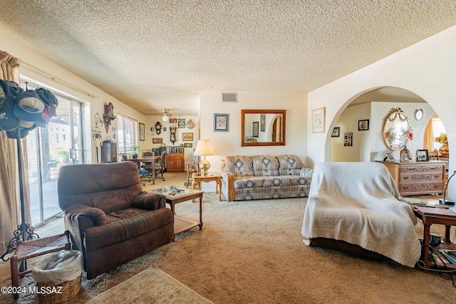 living room featuring carpet, a textured ceiling, and ceiling fan