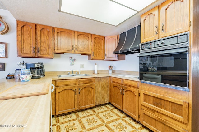 kitchen featuring electric cooktop, black oven, sink, and range hood