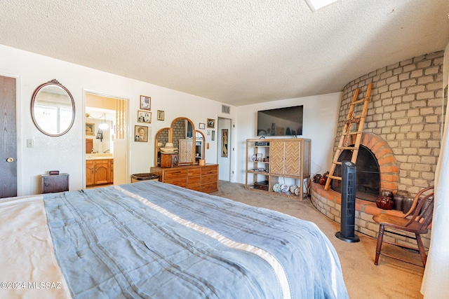 bedroom with a fireplace, a textured ceiling, and light carpet