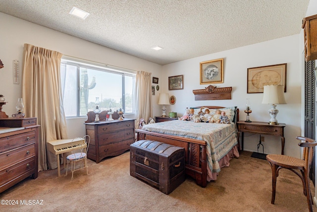 bedroom featuring light carpet and a textured ceiling