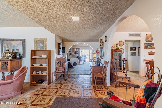 hallway featuring tile patterned floors and a textured ceiling