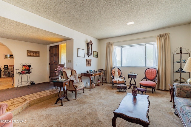 carpeted living room featuring a textured ceiling