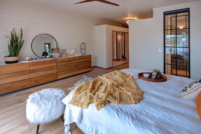 27 Circulo De Prado, Tubac, AZ 85646 - bedroom with light hardwood / wood-style floors, a closet, ceiling fan, and brick wall