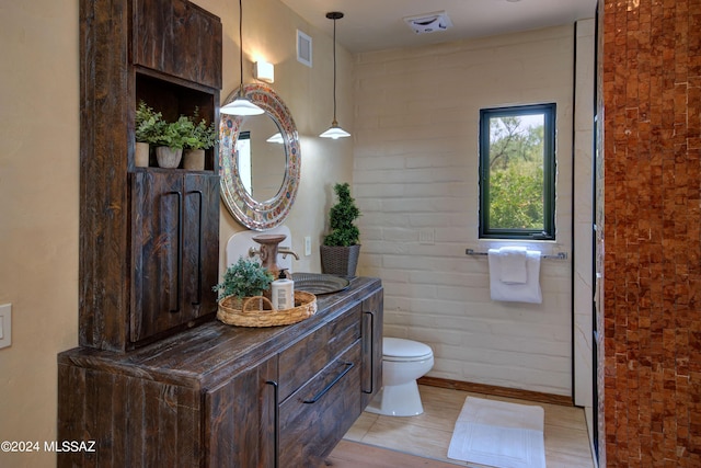 27 Circulo De Prado, Tubac, AZ 85646 - bathroom featuring vanity, toilet, and brick wall
