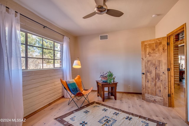 27 Circulo De Prado, Tubac, AZ 85646 - unfurnished room with ceiling fan, brick wall, and light wood-type flooring