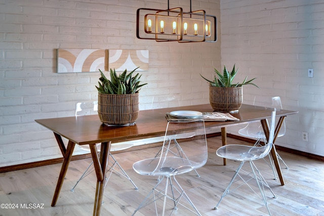 27 Circulo De Prado, Tubac, AZ 85646 - dining area featuring wood-type flooring, a chandelier, and brick wall