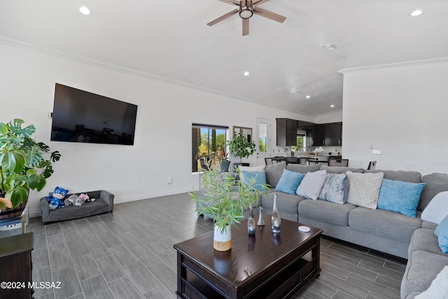 living room with ornamental molding, wood-type flooring, and ceiling fan