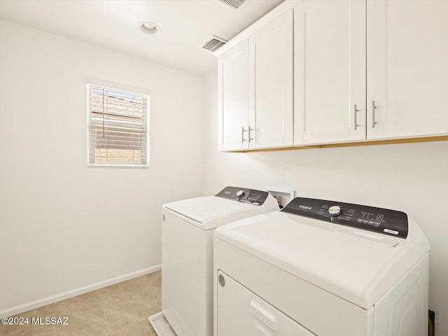 laundry room featuring washer and dryer and cabinets