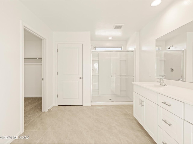 bathroom featuring walk in shower, tile patterned flooring, and vanity