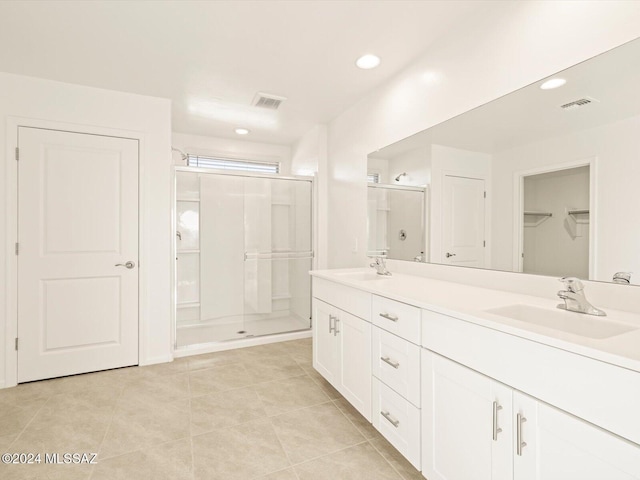 bathroom with an enclosed shower, vanity, and tile patterned floors