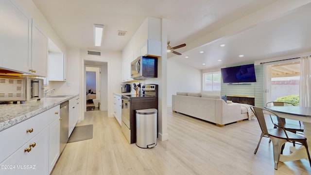 kitchen with ceiling fan, light stone countertops, appliances with stainless steel finishes, light hardwood / wood-style floors, and white cabinetry