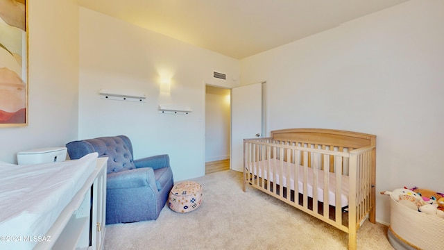 carpeted bedroom with a nursery area