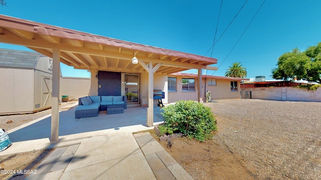 rear view of property with a patio area, outdoor lounge area, and a storage unit