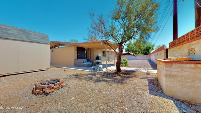 view of yard featuring a shed, a patio, and a fire pit