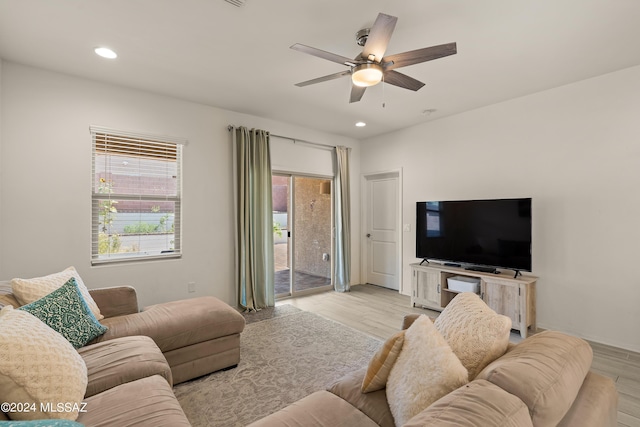 living room with light hardwood / wood-style floors and ceiling fan