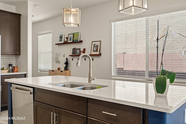 kitchen with decorative light fixtures, stainless steel dishwasher, sink, plenty of natural light, and dark brown cabinets