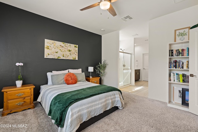 carpeted bedroom featuring ceiling fan and ensuite bath