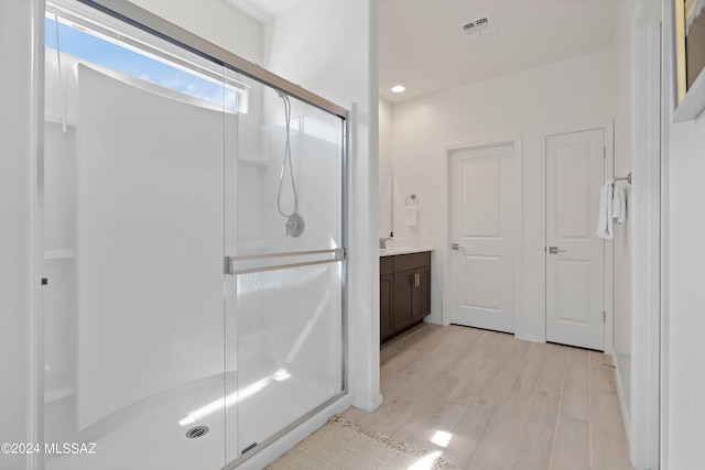 bathroom featuring vanity, wood-type flooring, and an enclosed shower