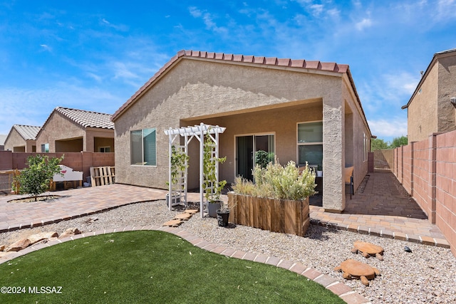 rear view of property featuring a patio area and a pergola